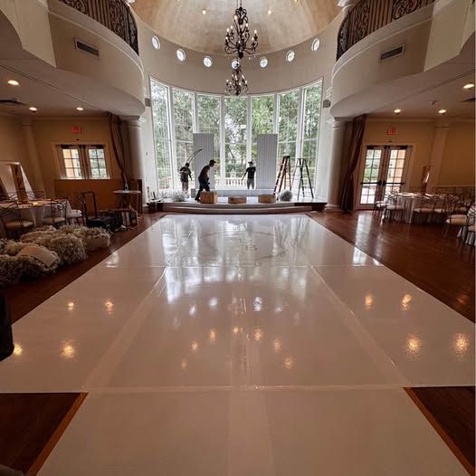 Dance floor lit by string lighting and a chandelier