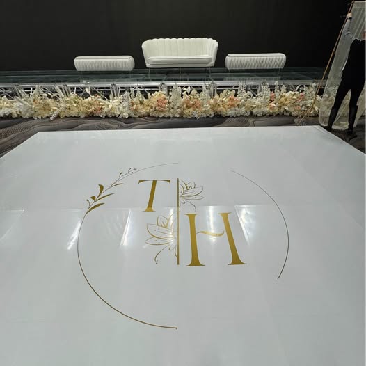 Wedding dance floor with a gold monogram and garland trim